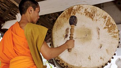 Drum. Buddhist monk in Luang Prabang, Laos, hitting temple drum. (Buddhism, religion, percussion)